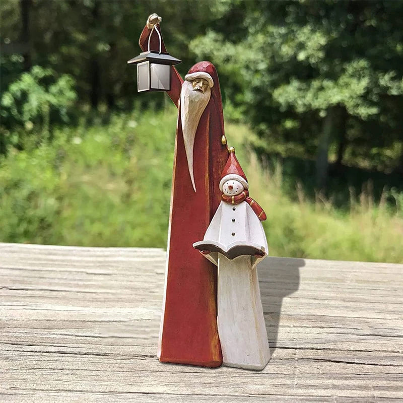 "Handgjord snögubbe juldekoration med LED-lykta, snöhatt, röd halsduk i trädgård, för magisk julstämning i hemmet."