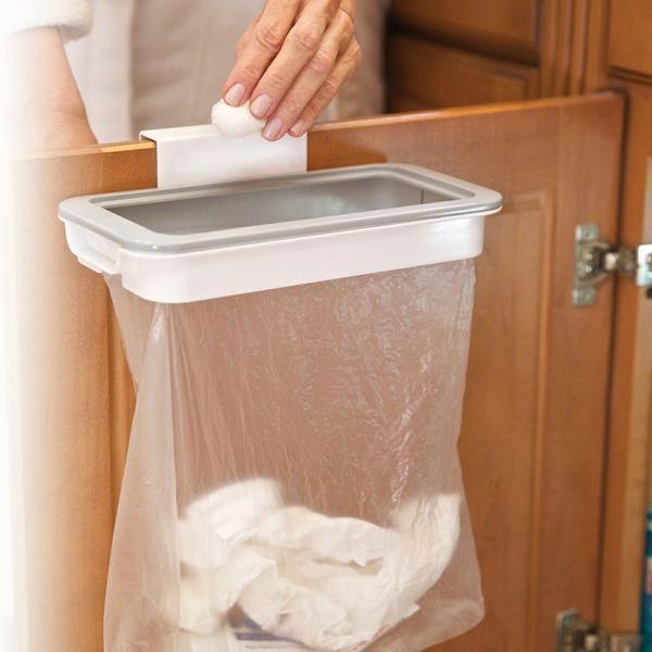 "Hängande papperskorgshållare i vit plast monterad på köksdörr, platsbesparande för smidig avfallshantering."