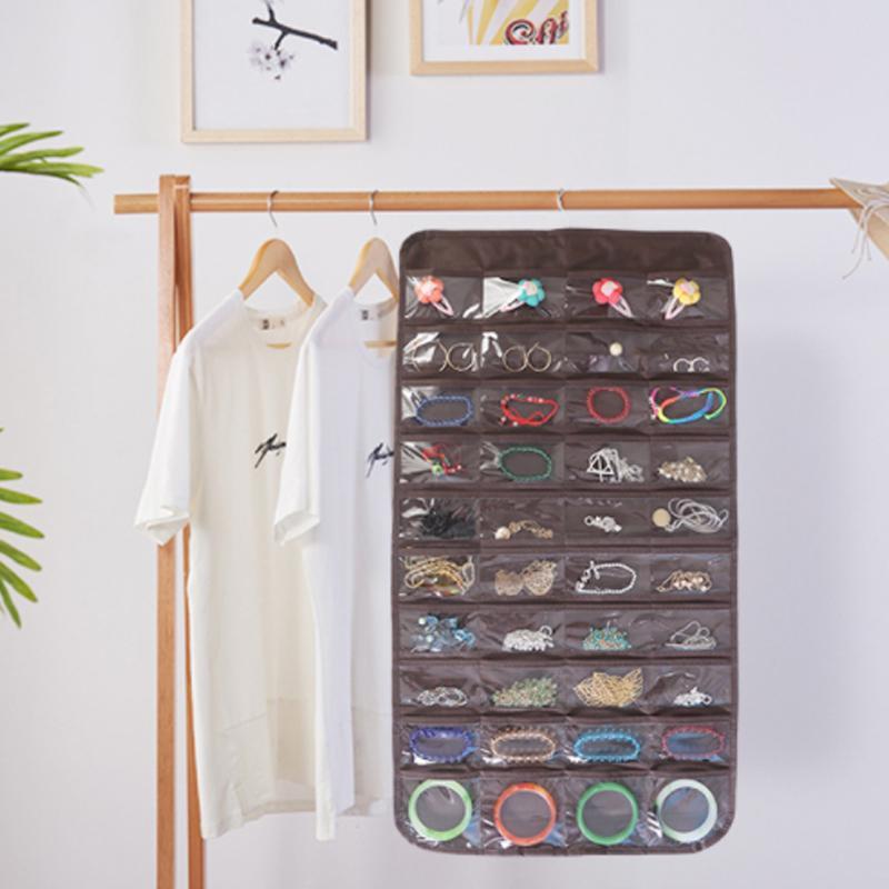 "Hängande transparent smyckesorganisatör med fickor och krokar, idealisk för organiserad smyckesförvaring för kvinnor."