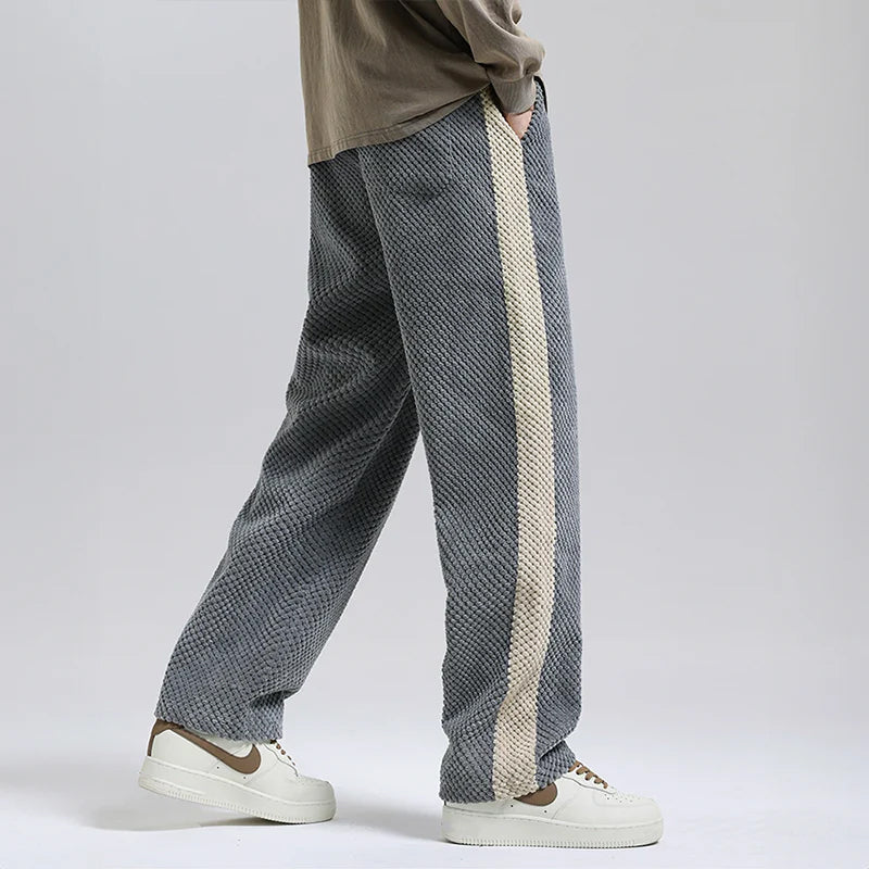 Man bär Herr Corduroy Byxor i svart, avslappnad passform, visar upp urban stil och sidrand