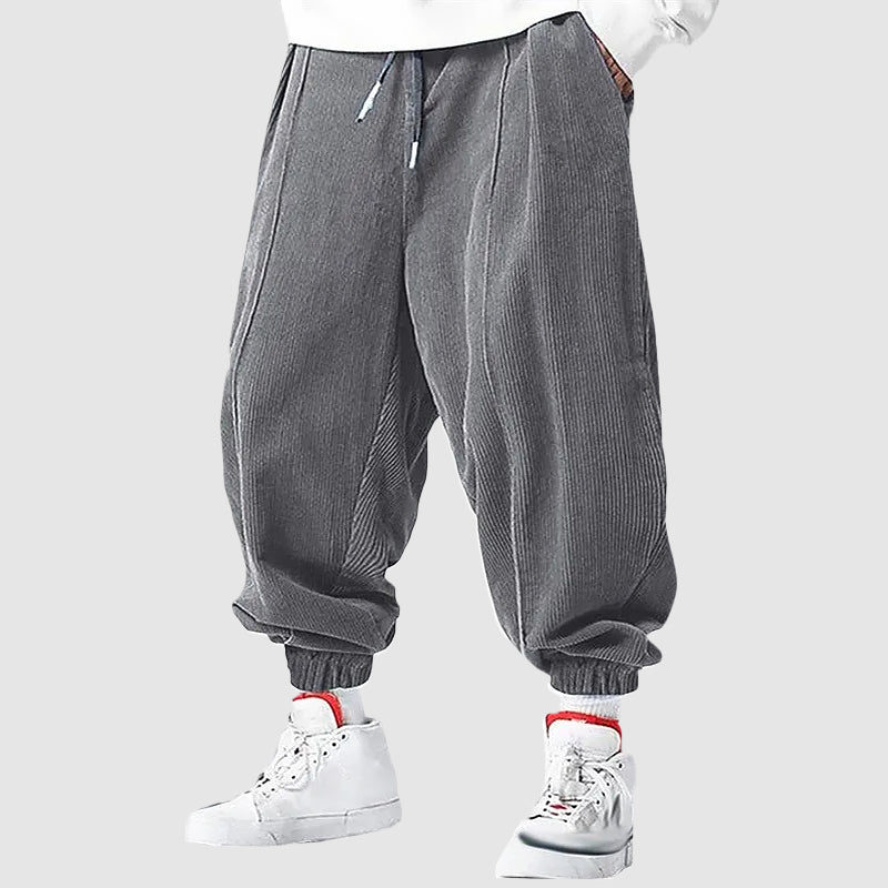 Man bär svarta sportiga joggingbyxor med elastiska muddar, perfekt för en avslappnad stil.
