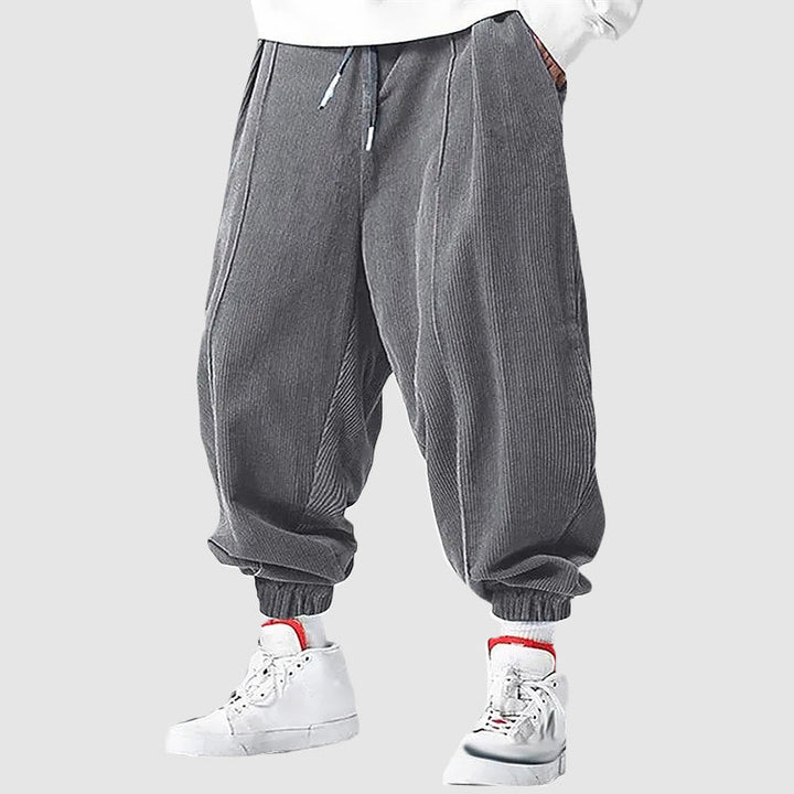 Man bär svarta sportiga joggingbyxor med elastiska muddar, perfekt för en avslappnad stil.