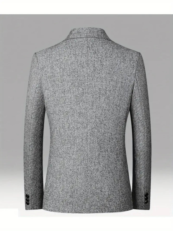 Man bär svart slimfit kavaj i modern stil, demonstrerar herrmode, idealisk för affärer eller fritid.
