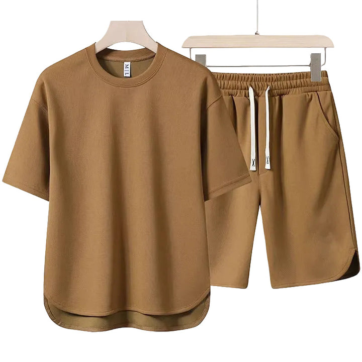 Herr sommarset med en överdimensionerad vit t-shirt och matchande svarta shorts, för ledig stil och bekväma fritidskläder.