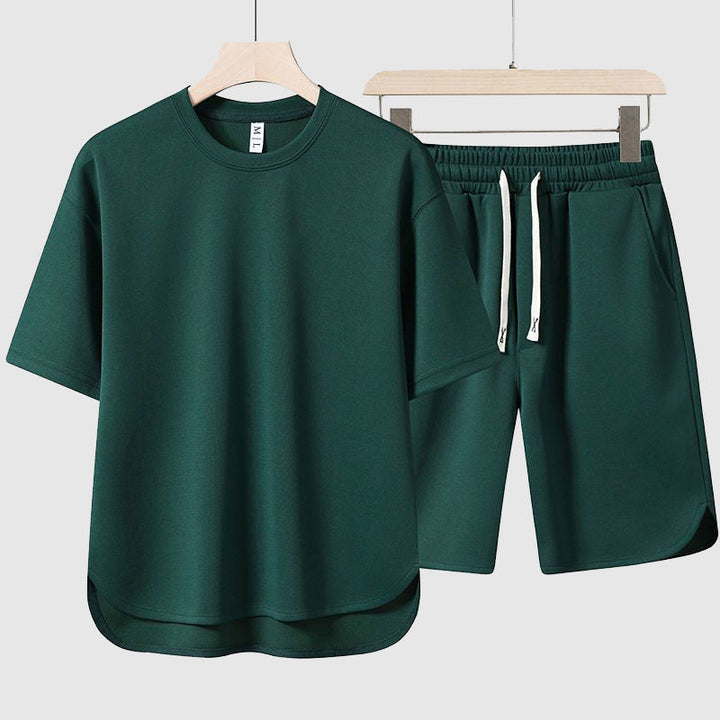 Man bär ett herrkomfortset bestående av en rymlig t-shirt och bekväma shorts, framifrån, perfekt för varma dagar.