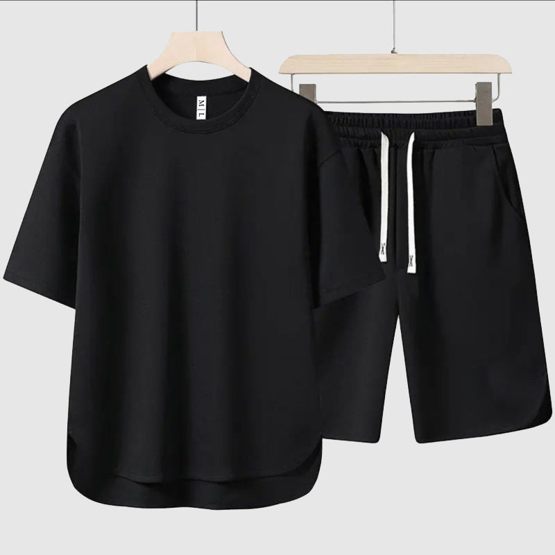 Snyggt herrklädesset med en lös t-shirt och lediga shorts i en sommarig färg, bekvämt och andningsbart.