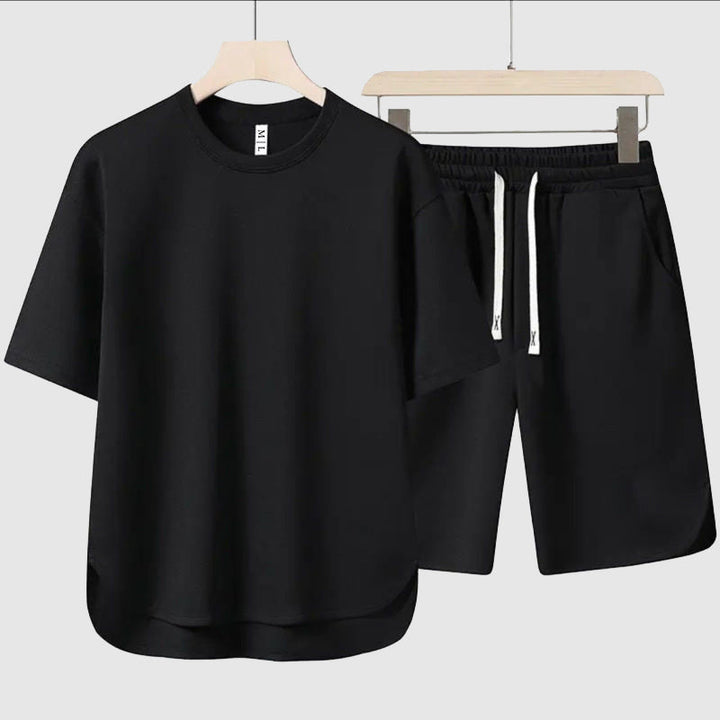 Snyggt herrklädesset med en lös t-shirt och lediga shorts i en sommarig färg, bekvämt och andningsbart.