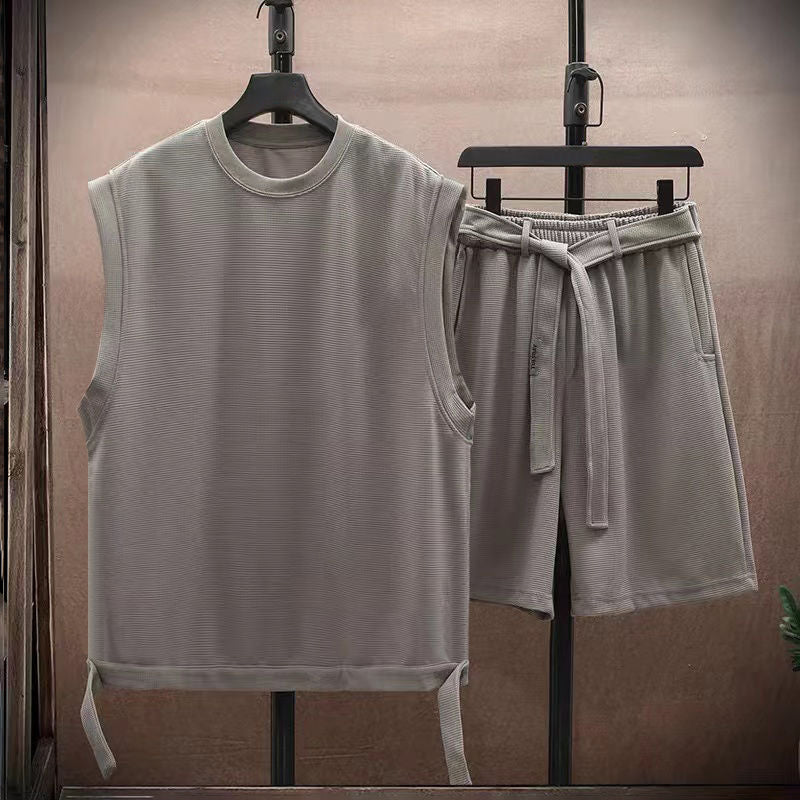 Detaljbild av herr sommarset, betonar ledig passform på ärmlös skjorta och shorts.