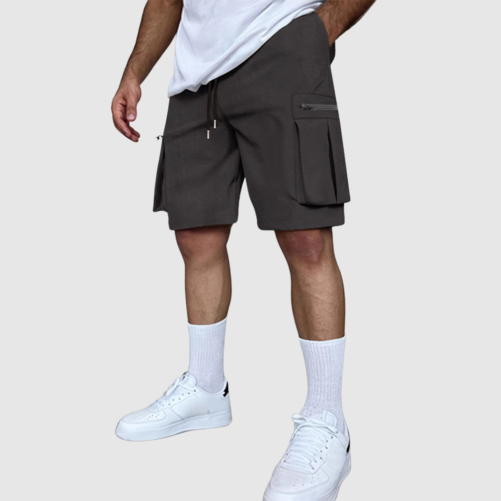 Närbild på tyget i herrars cargoshorts, framhävande dess slitstyrka och kvalitativa sömmar.