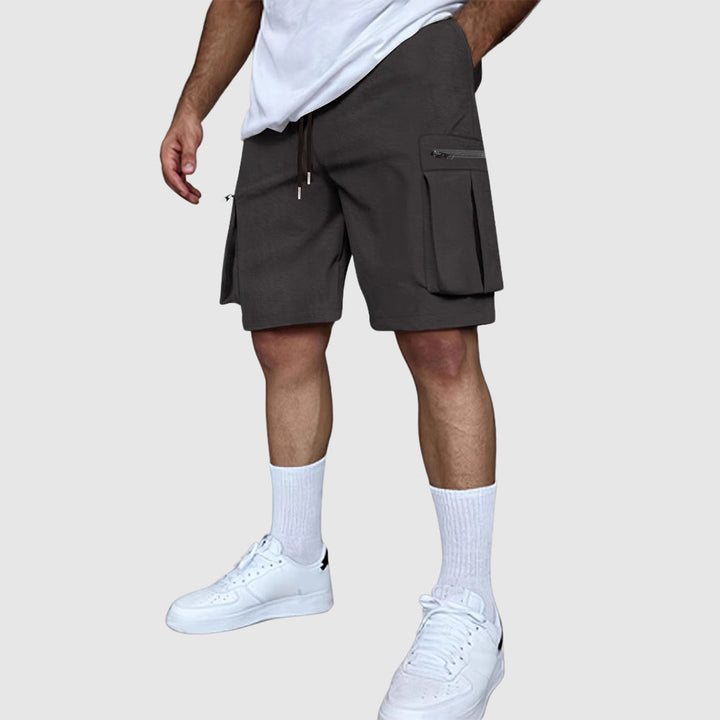 Närbild på tyget i herrars cargoshorts, framhävande dess slitstyrka och kvalitativa sömmar.