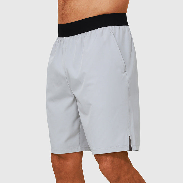 Man som springer utomhus iklädd herrars aktiva shorts med fickor, idealiska för träning.
