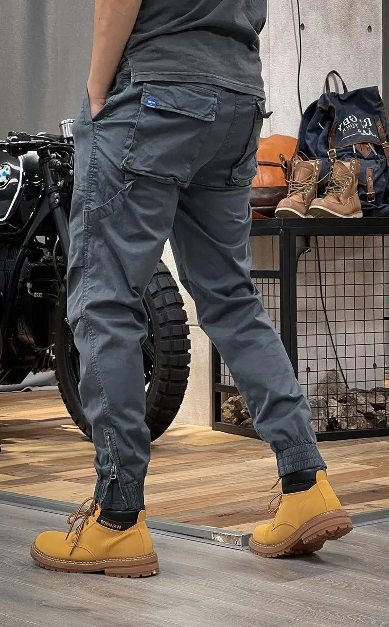 Modell bär bekväma herrars cargobyxor i camo-mönster, sidovy som framhäver passformen.