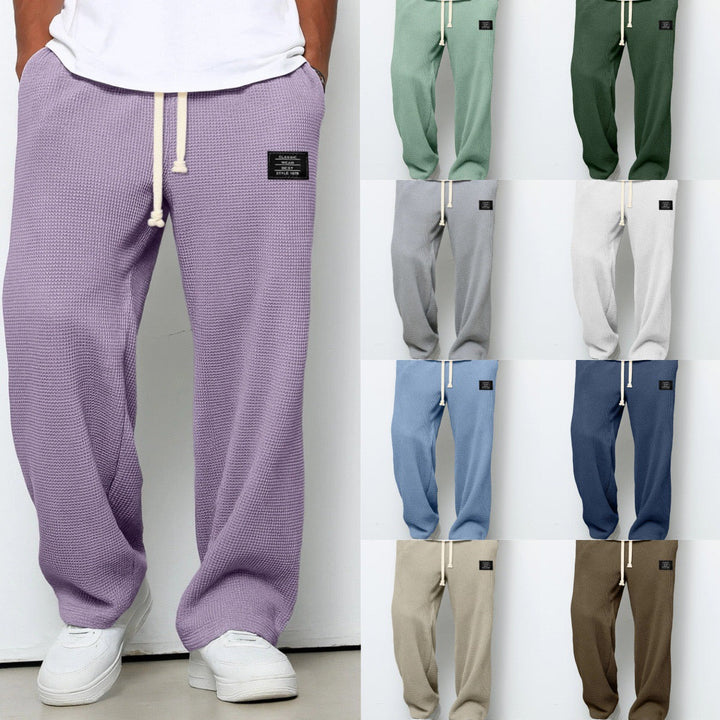 Man går i Herrbyxor Relaxed Fit med dragsko, uppvisar en ledig och modern stil för stad och fritid.