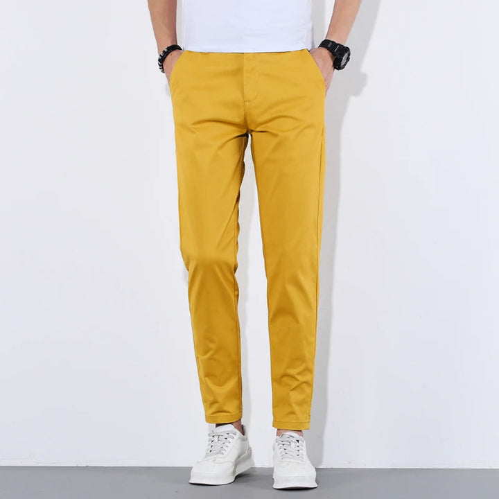 Man bär bekväma slim fit herrbyxor med avsmalnande ben, demonstrerar passformen