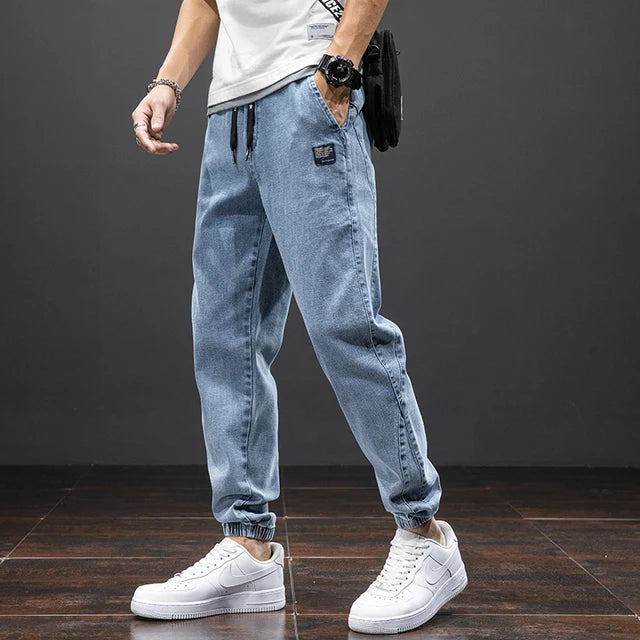 Närbild på textur av svarta herrjeans, avslappnad stil. Bekväma vardagsbyxor i denim.