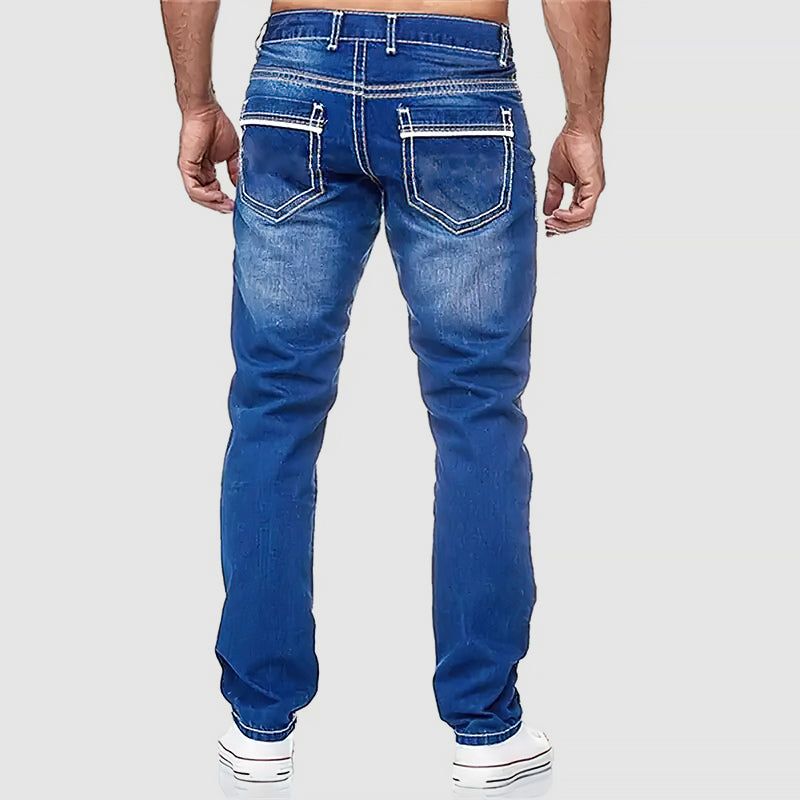 Modell som poserar i klassiska blå herrjeans, mångsidiga för olika tillfällen, bekväm passform.