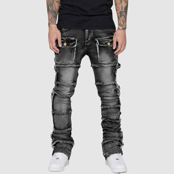 Närbild av slitna detaljer på herrjeans i distressed stil, framhäver den moderna designen och texturen.