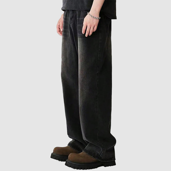 Detaljbild av blå denim herrjeans med breda ben, framhävande tyg och avslappnad stil.
