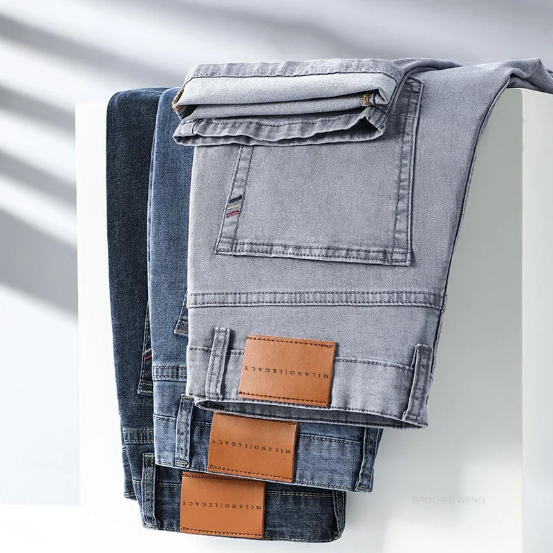 Detaljbild på hög midja herrjeans i mörkblå denim med rak passform, visar knapp och dragkedja.