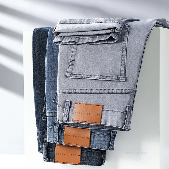Detaljbild på hög midja herrjeans i mörkblå denim med rak passform, visar knapp och dragkedja.