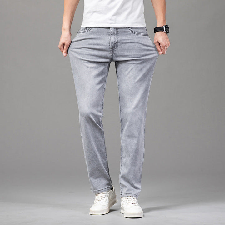 Närbild av tyget på mjuka grå herrjeans med rak passform, framhäver den klassiska men tidlösa stilen.