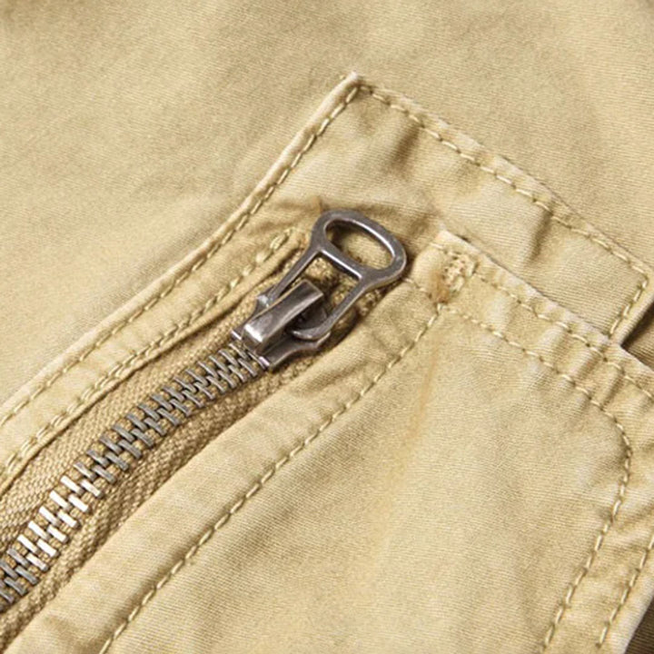 Detaljbild av elastisk midja med dragsko på sportiga herrjoggers, med praktiska lastfickor.