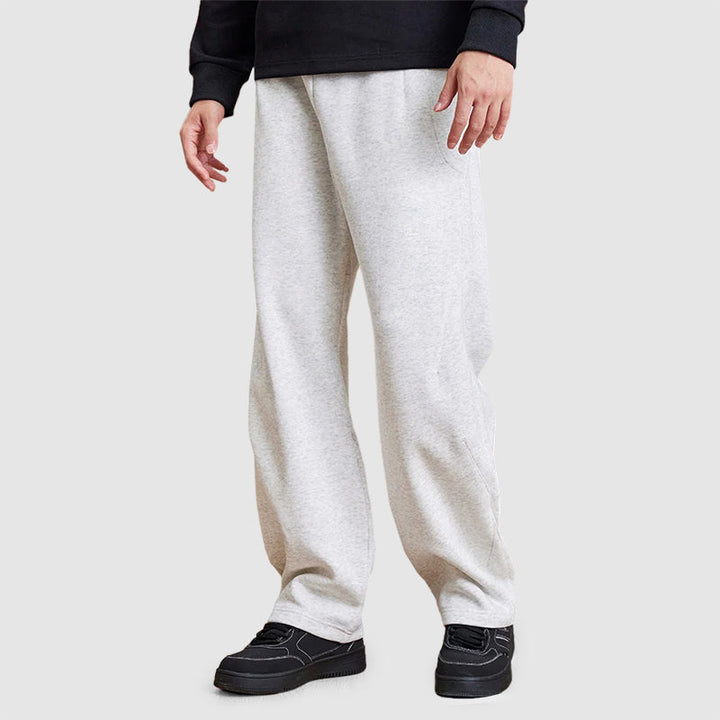 Detaljbild på männens raka ben-joggers, visar resår i midjan och tygets struktur. Casual byxor.