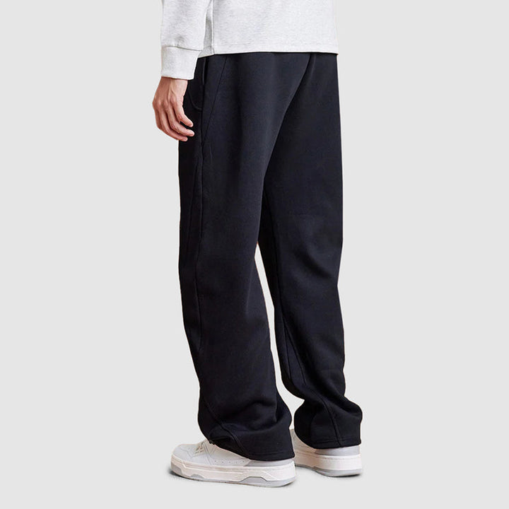 Man bär avslappnade raka ben-joggers i marinblått, demonstrerar passform och modern stil. Mänskläder.