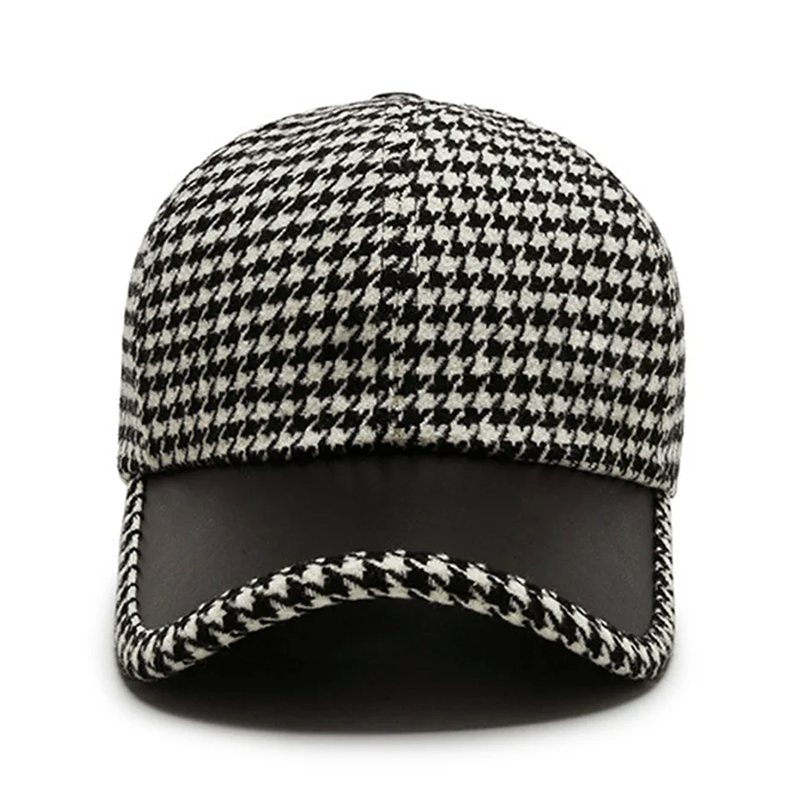Detaljbild av houndstooth-mönstret på herrkepsen och de kontrasterande konstläderdetaljerna.