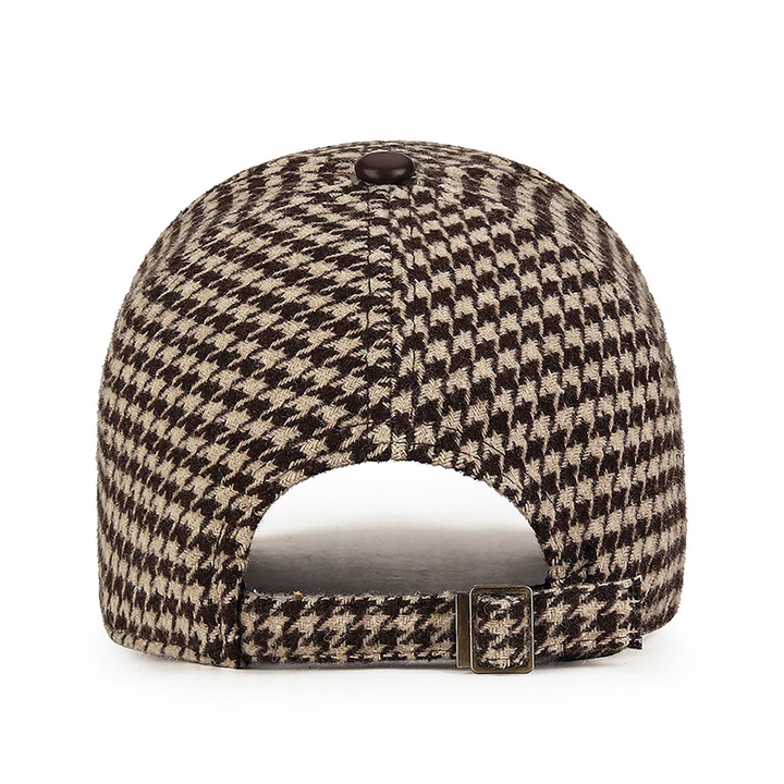 Stilren herrkeps med houndstooth-mönster och diskreta konstläderdetaljer, perfekt modeaccessoar.