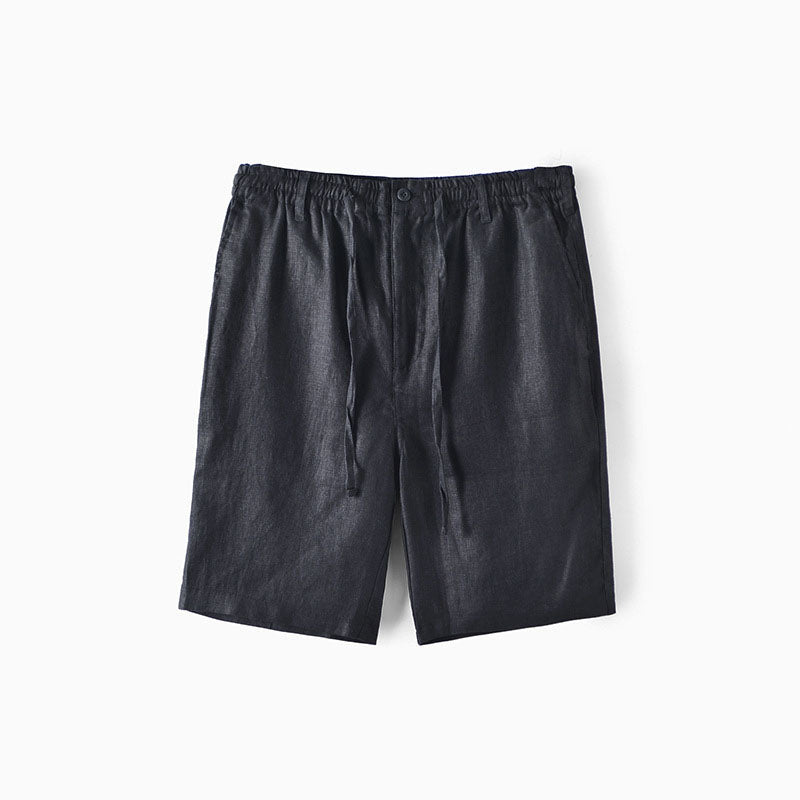 Modell bär beiga herrlinneshorts med elastisk midja, visar komfort och stil.