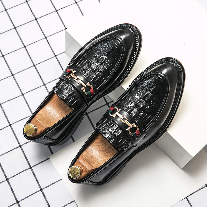 Svarta herrslip-on mockasiner med präglad design och smart metallbit, en stilig avslappnad sko.