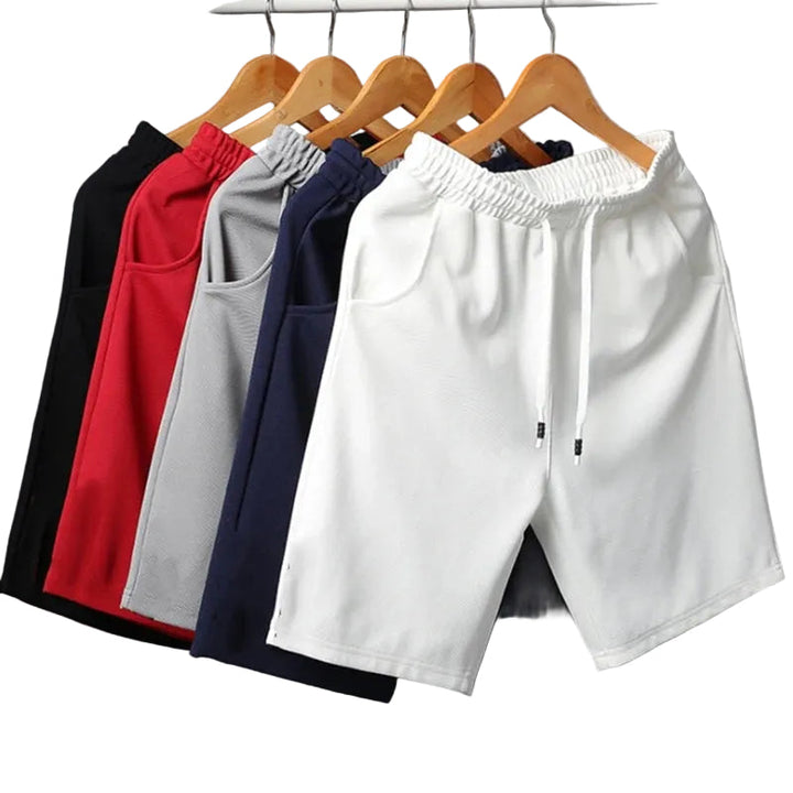 Närbild av blå herrshorts med bekväm elastisk midja och synliga sidofickor för sommarbruk.