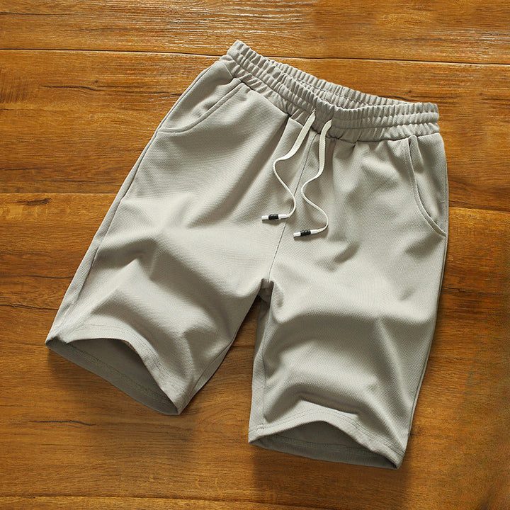 Somriga herrshorts i grön färg, med elastisk midja och sidofickor, bekväma för varma dagar.
