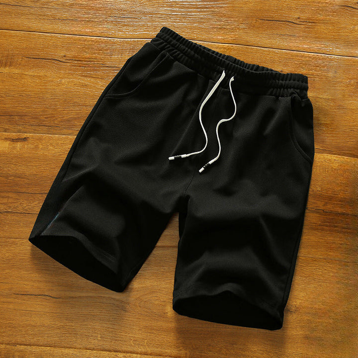 Detaljbild av tyg och sömmar på bekväma herrshorts med elastisk midja, idealiska för sommaren.