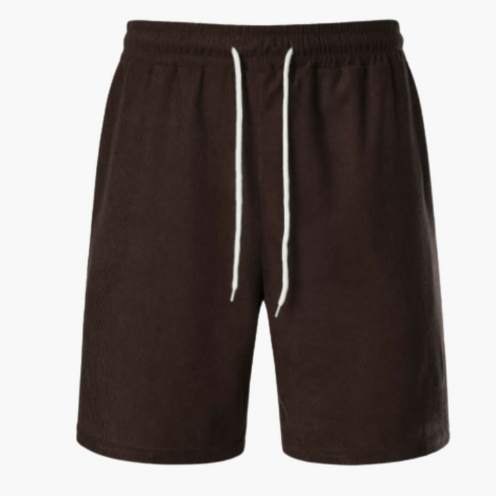 Man sitter bekvämt i ribbade herrshorts med dragsko. Ideal för avslappnad vardag och sommaraktiviteter.