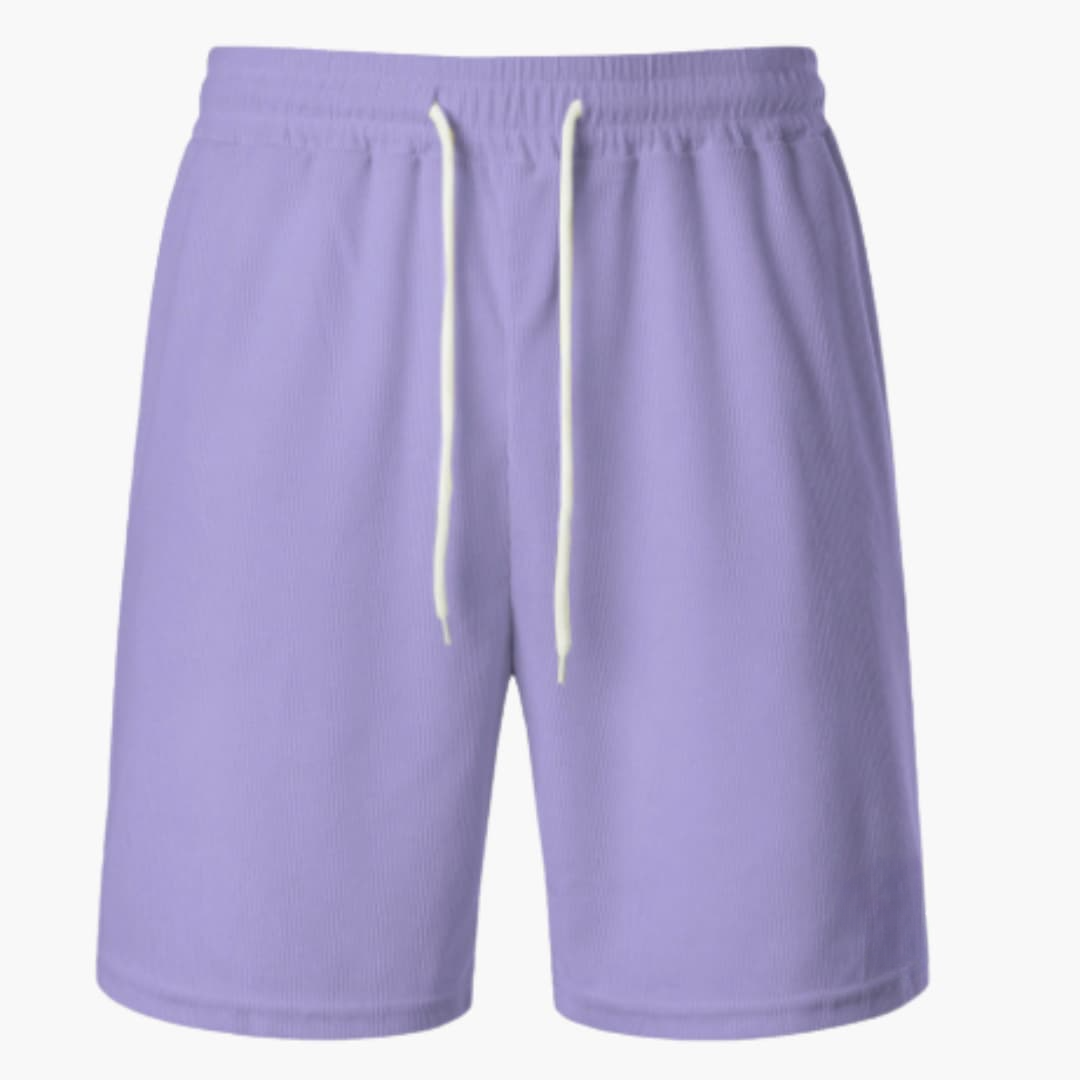 Man i ribbade herrshorts med dragsko njuter av sommaren utomhus. Bekväma fritidsshorts för avkoppling.