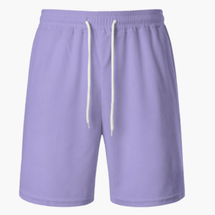 Man i ribbade herrshorts med dragsko njuter av sommaren utomhus. Bekväma fritidsshorts för avkoppling.