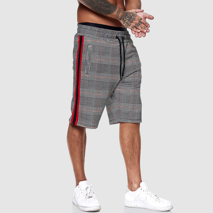 Modell bär rutiga herrshorts med dragsko, visar avslappnad passform och stil.