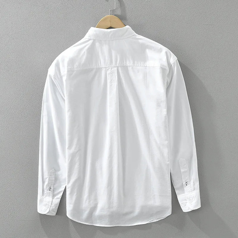 Man bär avslappnad herrskjorta med färgblock i grönt och beige, perfekt för vårdmode.