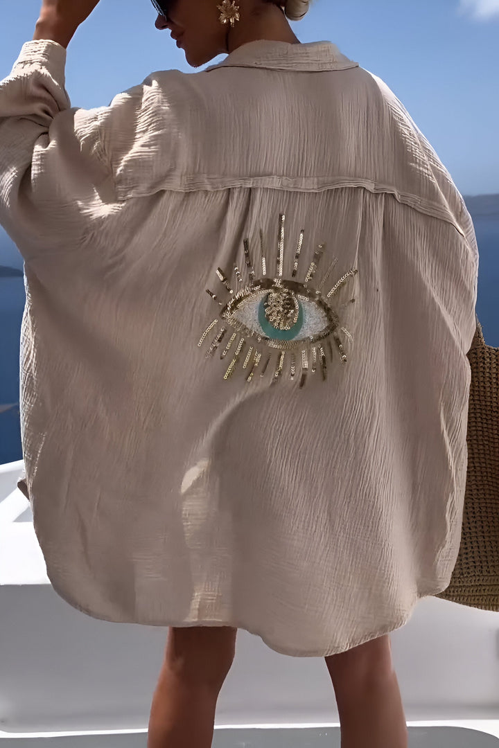 Detaljbild på tyg och pärldetaljer på en vit herrskjorta med rund hals och kort ärm, hög kvalitet