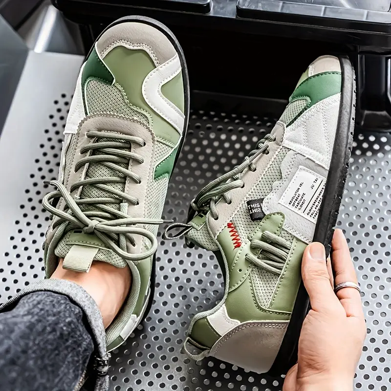 Herrsneakers i moderna färgblock, detaljerad vy av den skiktade designen och högkvalitativa material.