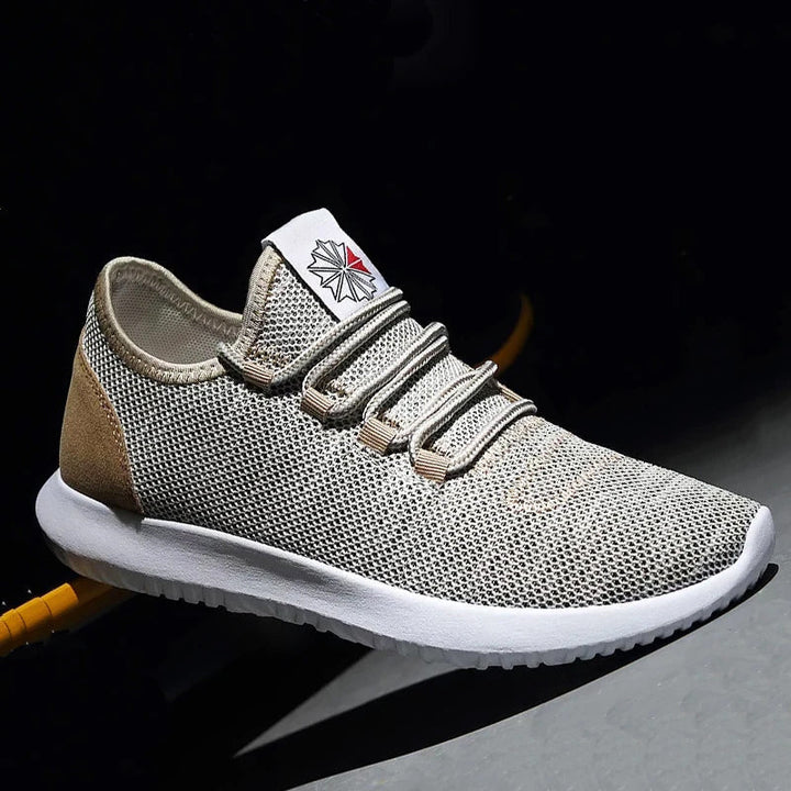 Närbild av grå herrskor i sneakerstil med snörning och andningsbar ovandel i mesh för optimal komfort.