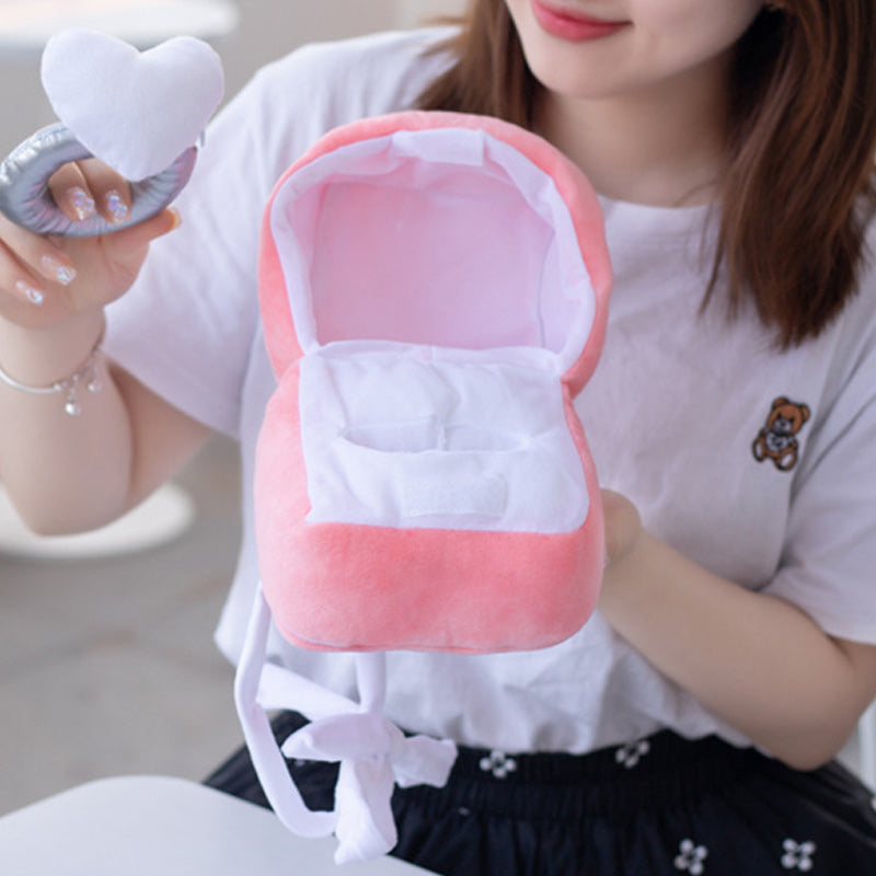 "Hjärtformad ringask i rosa plysch med dold dragkedja, perfekt för frieri och speciella tillfällen. Dekorativ och praktisk."