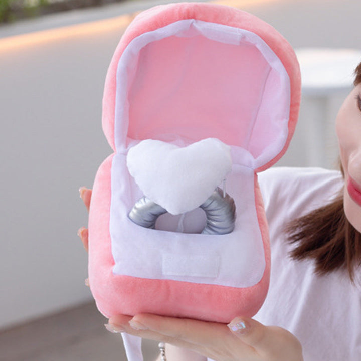 "Hjärtformad ringask i rosa plysch med dold dragkedja, perfekt för frieri och speciella tillfällen. Dekorativ och praktisk."