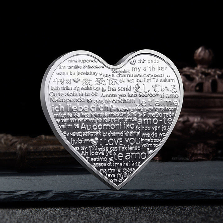 Hjärtformat minnesmynt med rosendesign i silver, kärleksbudskap; perfekt romantisk gåva, dekorativt och hållbart.