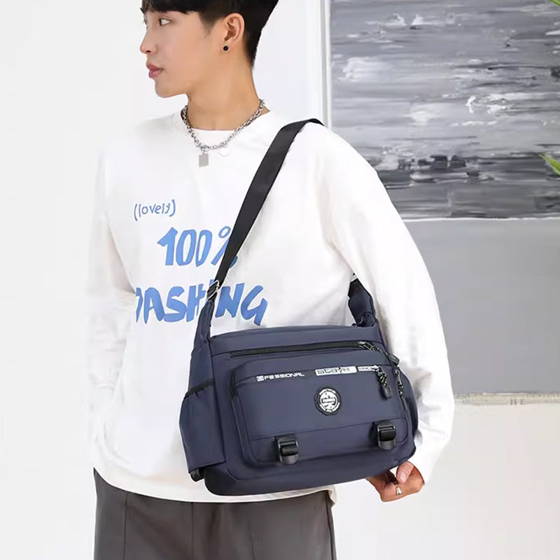 "Högkvalitativ svart axelväska för män med flera fickor, justerbara remmar och vattentät yta, sedd bakifrån."