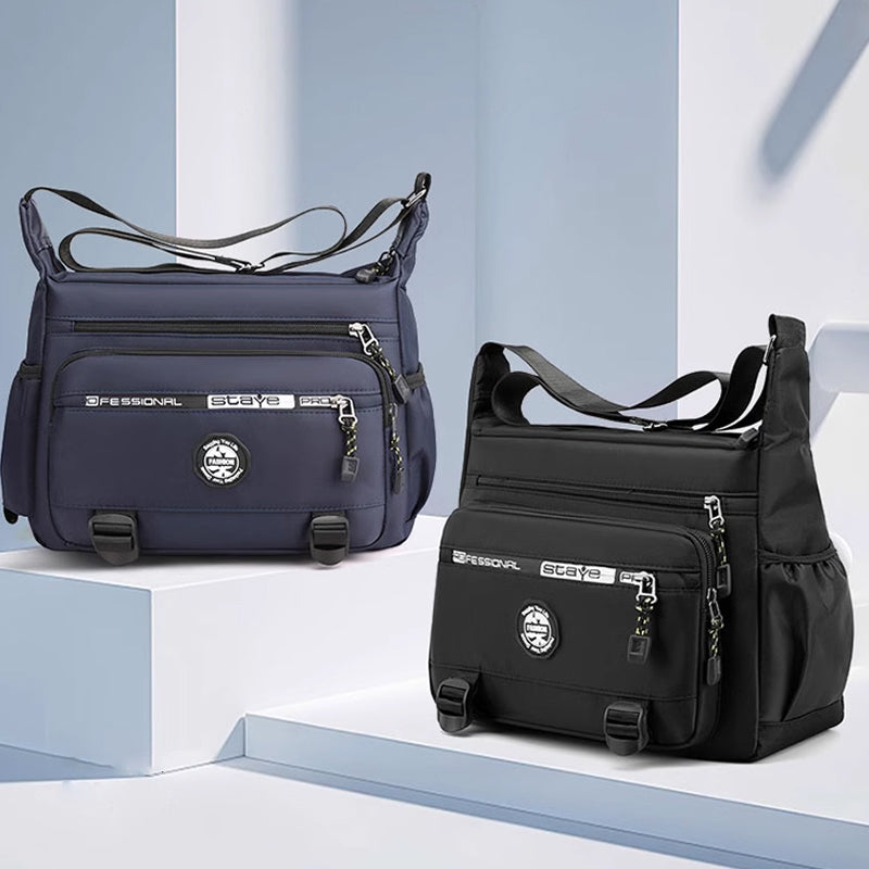 "Högkvalitativ svart axelväska för män med flera fickor, justerbara remmar och vattentät yta, sedd bakifrån."