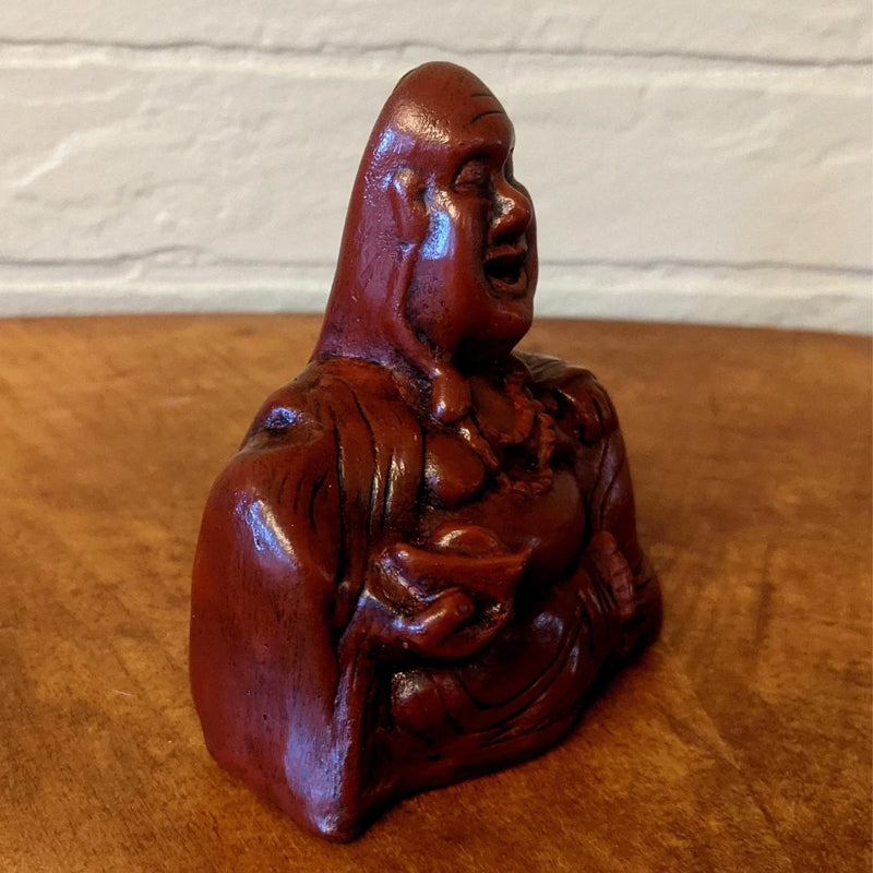 Humoristisk Buddha figur med utsträckt långfinger, gjord av harts, perfekt för skrivbord eller hylla, väcker skratt.