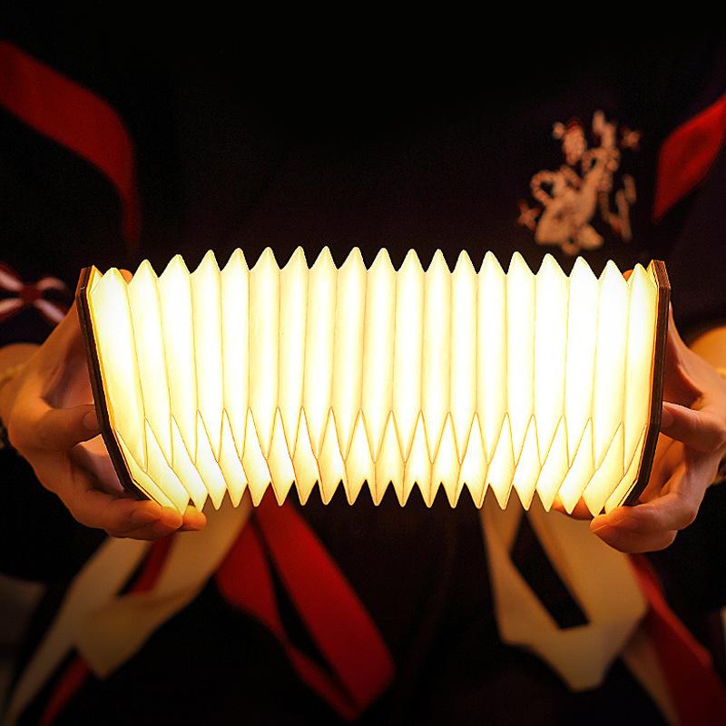 "Ihopfällbar trälampa i naturträ med USB-laddning, kompakt design för hemmet, bärkaraktär och modern estetik."